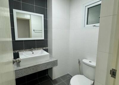 modern bathroom with a sink, mirror, toilet, and small window