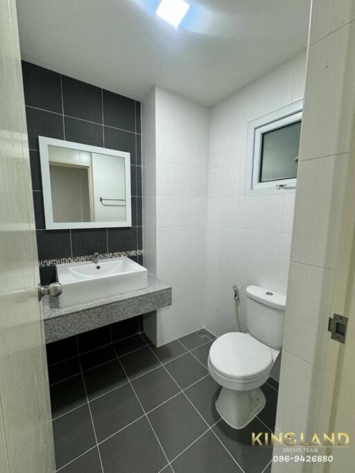 modern bathroom with a sink, mirror, toilet, and small window