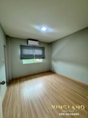 Spacious bedroom with wooden flooring and large window