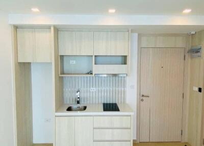 Modern minimalist kitchen area with built-in cabinets and stovetop