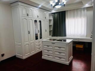 Spacious bedroom with white built-in wardrobes and a central island