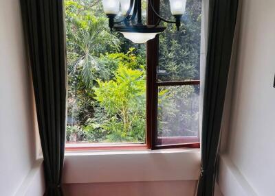 View of a staircase with a large window and greenery outside