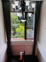 View of a staircase with a large window and greenery outside