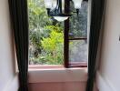 View of a staircase with a large window and greenery outside