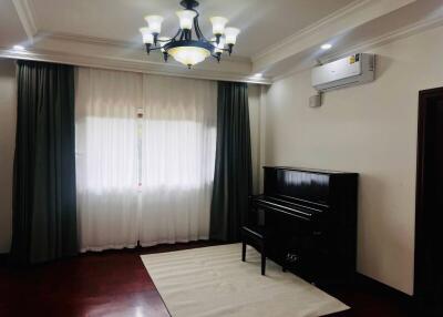 Living room with piano and overhead lighting