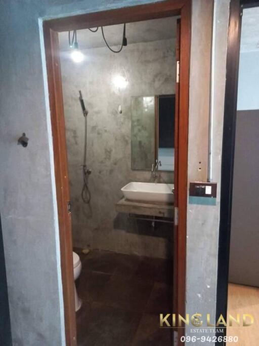 Bathroom with open shower, sink, and toilet