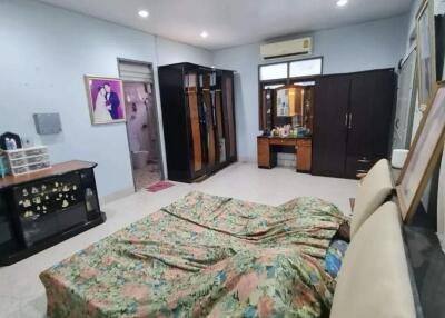 Spacious bedroom with a floral-patterned bed and various furniture