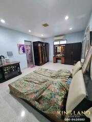 Spacious bedroom with a floral-patterned bed and various furniture