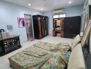 Spacious bedroom with a floral-patterned bed and various furniture