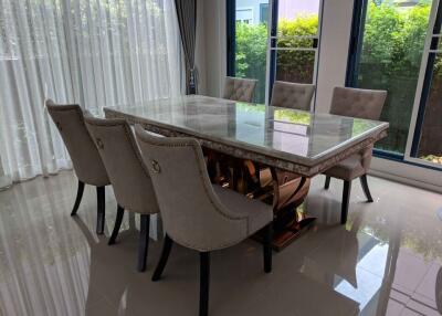 Modern dining area with six upholstered chairs and a large marble table