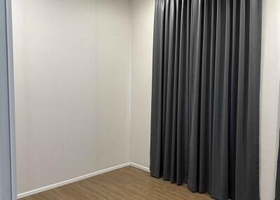 Empty room with wooden floor and gray curtains