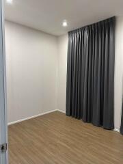 Empty room with wooden floor and gray curtains