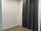 Empty room with wooden floor and gray curtains