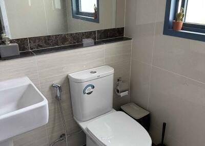 Modern bathroom with sink, toilet, and window