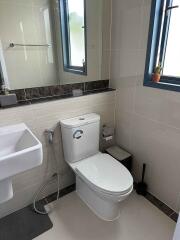 Modern bathroom with sink, toilet, and window