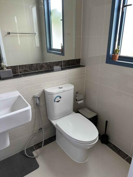 Modern bathroom with sink, toilet, and window