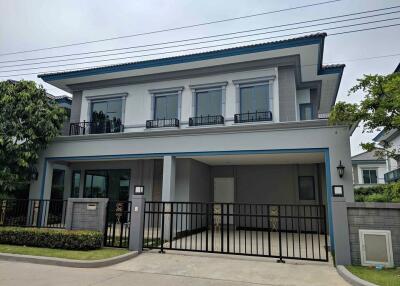 Front view of a modern two-story house with a gated driveway