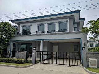 Front view of a modern two-story house with a gated driveway