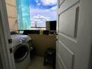 A view of a balcony with a washer and a scenic view outside