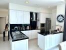 Modern kitchen with white cabinets and black countertops