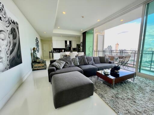 Spacious living room with modern decor and large windows offering city views