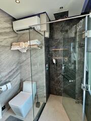 Modern bathroom with glass shower enclosure and grey tiles