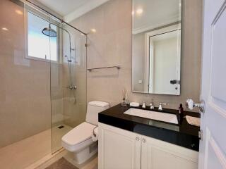 Modern bathroom with glass shower and black countertop