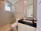 Modern bathroom with glass shower and black countertop