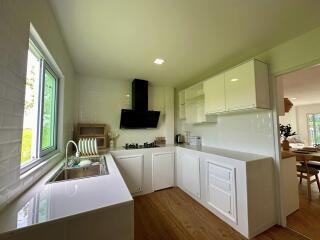 Modern kitchen with white cabinets and wooden flooring