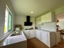 Modern kitchen with white cabinets and wooden flooring