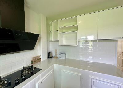 Modern kitchen with white cabinets, black stove, and built-in appliances