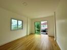 Bedroom with wooden floor, window, and access to balcony