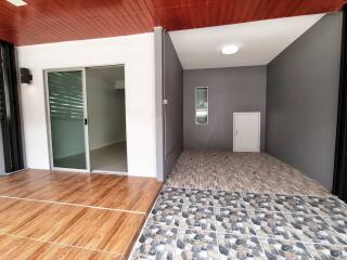 Open area adjacent to a room with sliding glass door, tiled flooring, and wooden ceiling