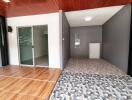 Open area adjacent to a room with sliding glass door, tiled flooring, and wooden ceiling