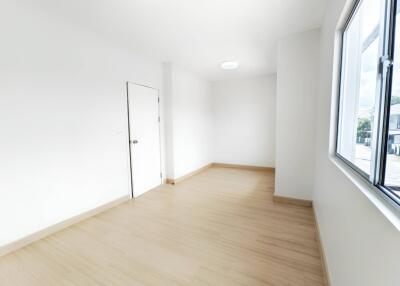 Empty bright room with wooden floor and large window