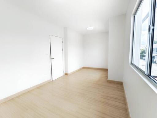 Empty bright room with wooden floor and large window