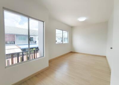 Spacious bedroom with large windows and wooden flooring