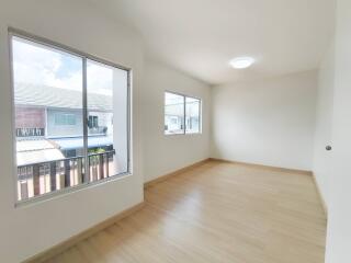 Spacious bedroom with large windows and wooden flooring