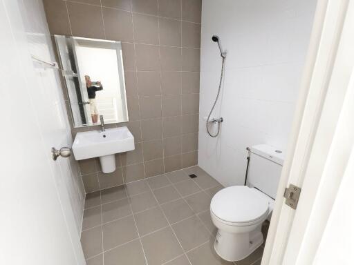 Modern bathroom with tiled walls and floor, including sink, toilet, and shower.