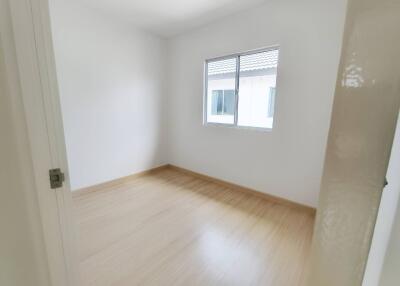 Bright empty bedroom with wooden flooring and window