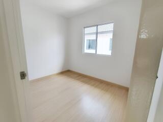 Bright empty bedroom with wooden flooring and window