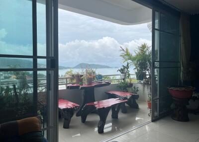 Balcony with outdoor seating and view of the sea