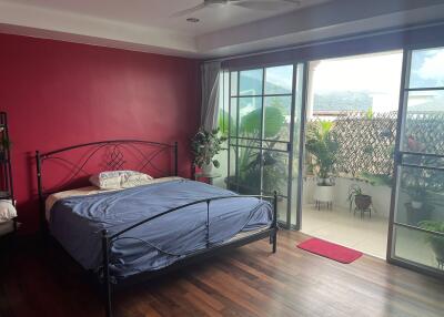 Spacious bedroom with large glass doors leading to a balcony