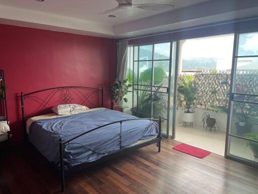 Spacious bedroom with large glass doors leading to a balcony