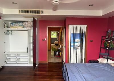 Bedroom with closet, ceiling fan, and bright red walls