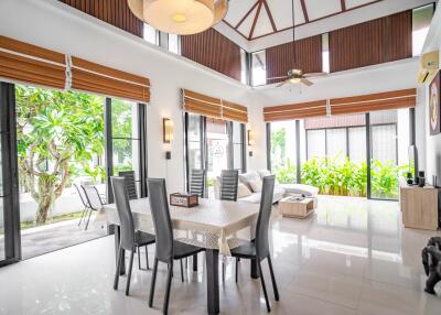 Spacious, well-lit dining and living area with large windows and garden view