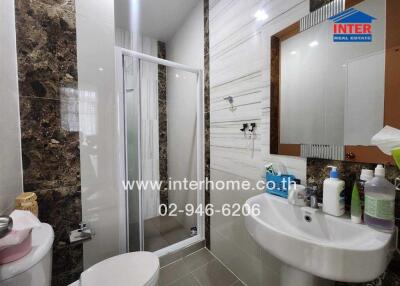 Modern bathroom with shower, sink, mirror, and tiled walls