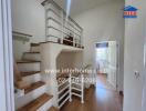 Staircase area with wooden steps and white railings leading to upper floor