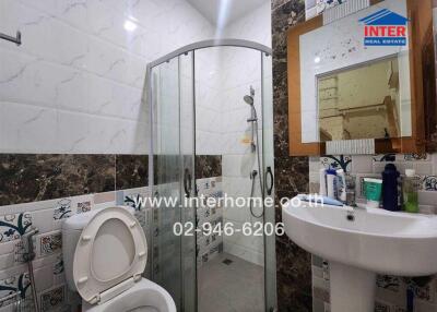 Modern bathroom with glass shower, sink, and toilet