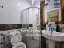 Modern bathroom with glass shower, sink, and toilet